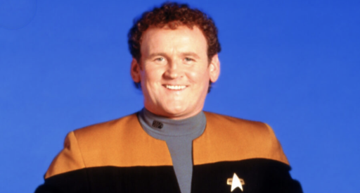 portrait of the character "Miles Edward O'Brien" from Star Trek.

The background is dark blue.

He is facing front, smiling into the camera.