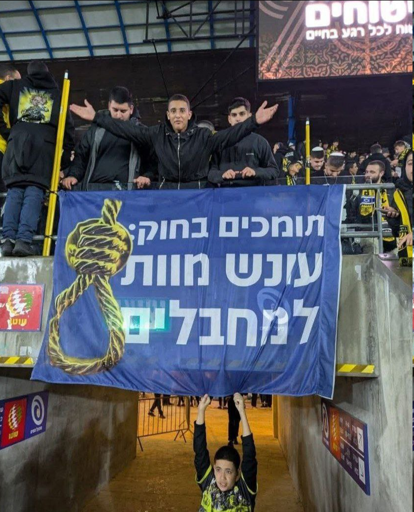picture of a banner in Hebrew with a noose at a football even in Israel